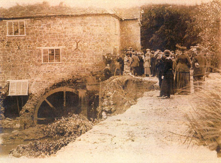 crowd looking at damaged waterwheel
